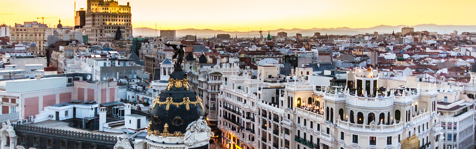 The rooftops of older, moderately-tall buildings at sunset.